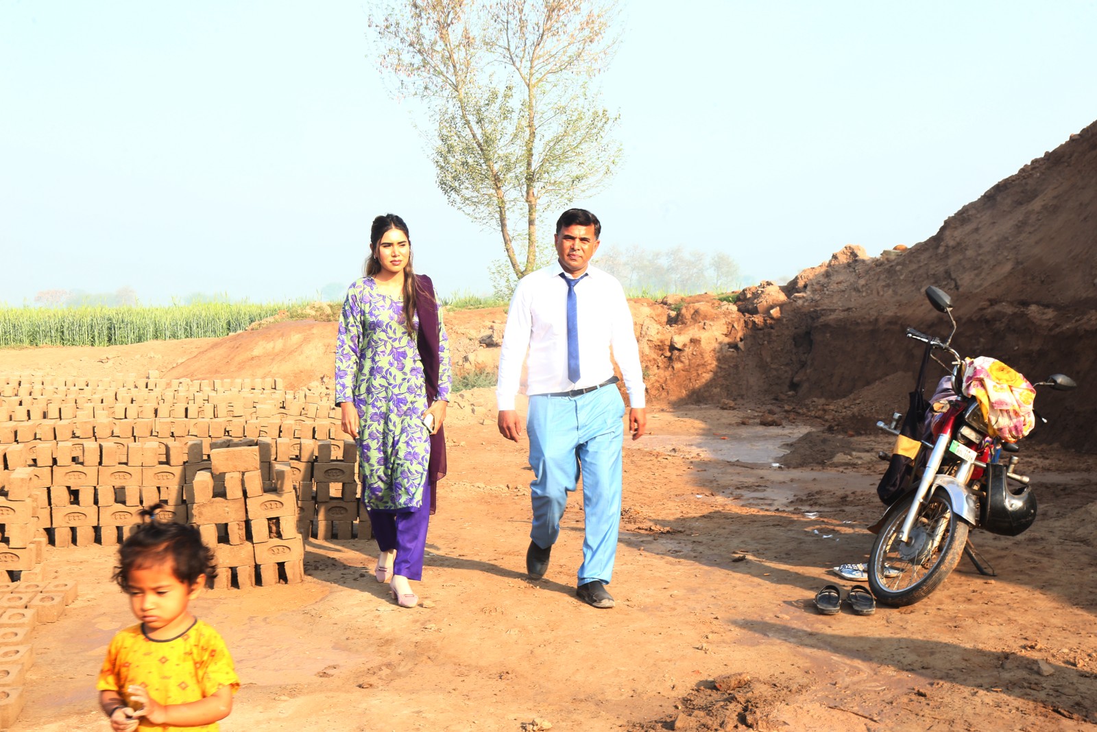 TLUCF team members visiting a family at the kiln, with a toddler in the foreground