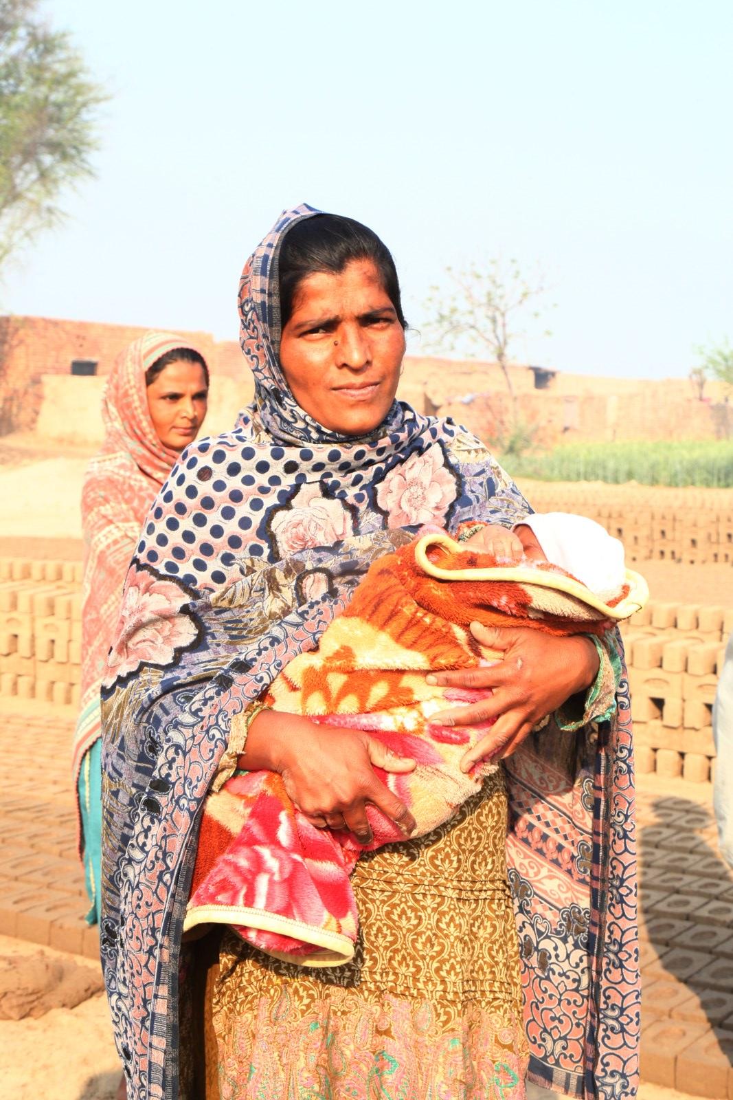 A mother holding her baby at the kiln